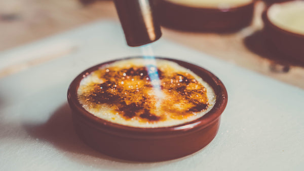 Crème brûlée brander karamelliseert suiker met een jetvlam